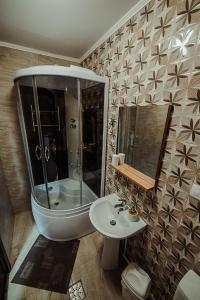 a bathroom with a shower and a sink and a mirror at Casa din Valea Bucovinei in Valea Moldovei