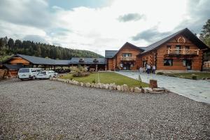 a log cabin with cars parked in front of it at Casa din Valea Bucovinei in Valea Moldovei