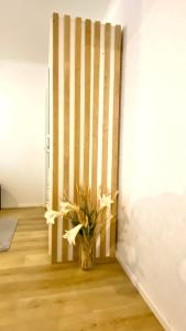 a vase with flowers in a room with a wall at City Pearl II in Jyväskylä +1 photo