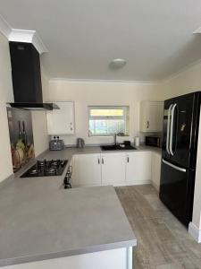 a kitchen with white cabinets and a black refrigerator at Sharpley Hall Garden Studio not far from Seaham Beach offering Quiet Private Stay with Secure Parking in Seaham +4 photos