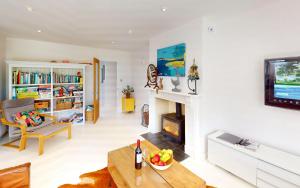 a living room with a fireplace and a table at CROYDE MARRAM 5 Bedrooms in Croyde
