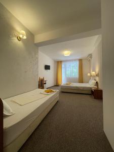 a hotel room with two beds and a window at Alatoni Beach Hotel in Sozopol