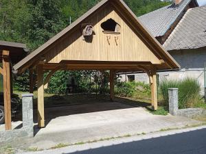 a wooden pavilion with a door on a house at Apartmaji Stara Šola in Bohinjska Bistrica