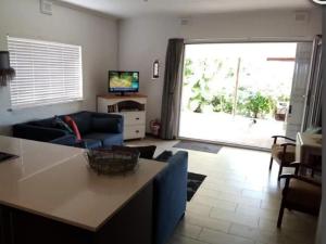 un soggiorno con un divano blu e una TV di Sunshine Cottage a Pennington