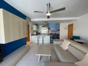 a living room with a couch and a kitchen at Terrasol Torrelitoral Ático 1 Dormitorio in Torre del Mar