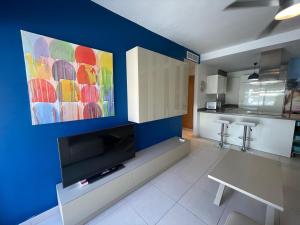 a living room with a tv and a kitchen at Terrasol Torrelitoral Ático 1 Dormitorio in Torre del Mar +1 photo