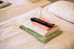 a pile of towels sitting on top of a bed at Tabist Healthy Pal Akagi in Shibukawa