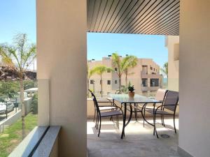 マラガにある1º Línea de playa con piscina panorámica & parkingのバルコニーにテーブルと椅子が置かれたパティオ