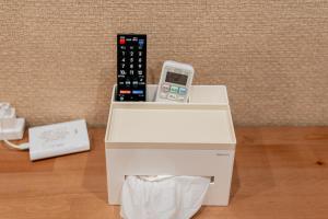 a remote control sitting on top of a white box at Value Osaka Tengachaya Namba Condo in Osaka