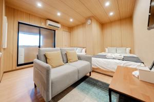 a room with a couch and a bed and a table at Value Osaka Tengachaya Namba Condo in Osaka
