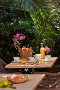 - une table avec de la nourriture et du jus d'orange dans l'établissement Logis Hotel Le Lonca, à Porto Ota