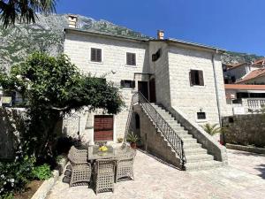 a building with a table and chairs in front of it at Lazovic- Apartment by the Sea with Amazing View in Dobrota