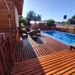 una terrazza in legno accanto alla piscina di CABAÑAS LA AMISTAD a Puerto Iguazú