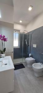 łazienka z 2 umywalkami, prysznicem i toaletą w obiekcie Le Dimore di Donato w mieście Torre San Giovanni Ugento