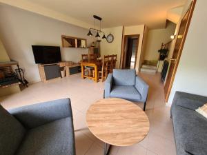 Una sala de estar con una mesa y sillas y un televisor. en Magnífic dúplex amb doble terrassa, en Sant Joan de les Abadesses