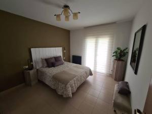 Un dormitorio con una cama grande y una ventana en Magnífic dúplex amb doble terrassa, en Sant Joan de les Abadesses