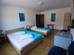 a hotel room with two beds and a table at Casa Rustica Apart & Rooms in Cîmpineanca