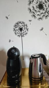 a dandelion sticker on a wall next to a tea kettle at Melissa lux in Ciampino