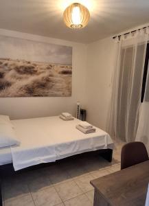 ein Schlafzimmer mit einem Bett und einem Gemälde an der Wand in der Unterkunft Kuća za odmor-Val in Vir