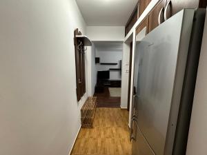 a hallway leading to a room with a refrigerator at Zlata Cozzy Apartment USV in Suceava +1 photo