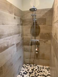 a bathroom with a shower with wooden walls at Chambre d'hôte in Monflanquin