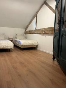 a room with two beds and a wooden floor at Maison de famille in Trélissac