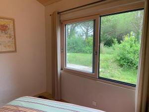 a bedroom with a window looking out at a yard at Chambre d'hôte in Monflanquin