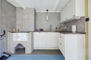 a kitchen with white cabinets and a fireplace at The Haukland House, Between Peaks & Sea in Leknes +32 photos