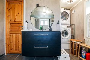 a bathroom with a navy blue dresser and a mirror at The Haukland House, Between Peaks & Sea in Leknes