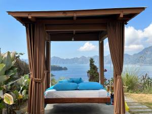 a canopy bed with a view of the water at Kubah Bali Glamping in Kintamani