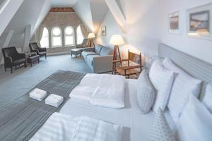 a bedroom with a large bed and a living room at Regatta Spa Hotel in Hanko