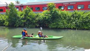 two people in a kayak on a river with a train at Bell Farms and Resorts in Munroe Island