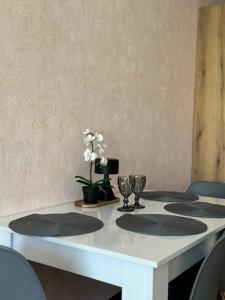 a white table with chairs and flowers on it at Студия Sea Breeze in Sveti Vlas