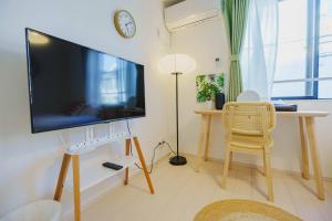 Una televisión o centro de entretenimiento en QH203, Newly renovated hotel, direct access to Ueno, Asakusa, Disneyland, Airport