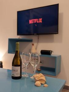 a bottle of wine and two wine glasses on a table at Vila de Matiz in Vila do Porto