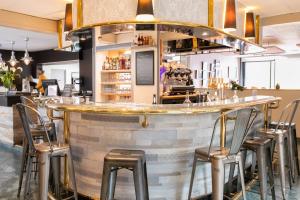 a bar with stools in a restaurant at Logis Hotel Restaurant Au Chêne Vert, Saint-Brieuc in Plérin +37 photos