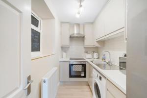 a white kitchen with a sink and a dishwasher at Modern Two Bedroom Central Flat in Weston-super-Mare