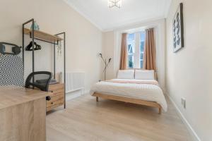 a bedroom with a bed and a dresser and a window at Modern Two Bedroom Central Flat in Weston-super-Mare
