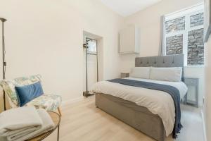 a bedroom with a bed and a chair in it at Modern Two Bedroom Central Flat in Weston-super-Mare +1 photo