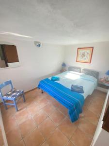 コスタ・パラディーゾにあるappartamento con incantevole vistaのベッドルーム(青いベッド1台、椅子付)