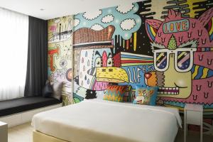 a bedroom with a painted wall with a bed at Beat Hotel Bangkok in Bangkok