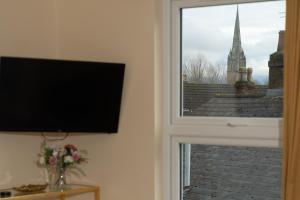 a window with a tv and a view of a church at Caboose in Salisbury