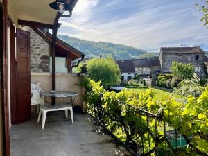 a patio with a table and a view of a garden at La Petite Ourse maison de village à Oust in Oust