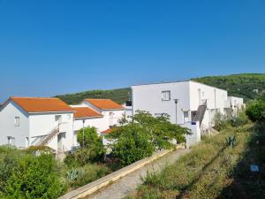 a row of white houses on a hill at Studio Apartman Bubi in Nečujam