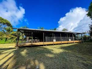 a house with a large building in a field at The Pavilion - Rarotonga in Arorangi
