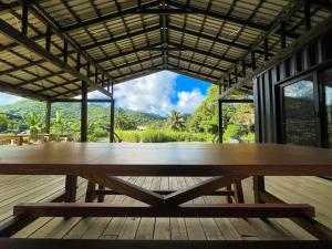 a large wooden table sitting on a wooden deck at The Pavilion - Rarotonga in Arorangi