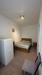 a small bedroom with a bed and a chair in it at Two Bedroom Flat Close to Newcastle City Centre in Elswick