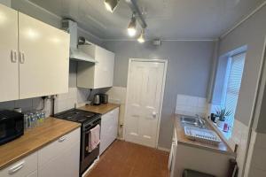 a kitchen with white cabinets and a stove top oven at Two Bedroom Flat Close to Newcastle City Centre in Elswick +12 photos