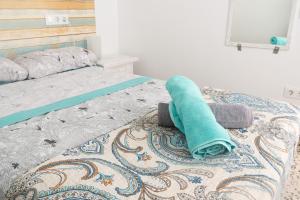 a bed with a turquoise towel laying on it at Daydream Medano Coliving in El Médano