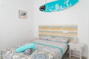a bedroom with a bed with a surfboard on the wall at Daydream Medano Coliving in El Médano